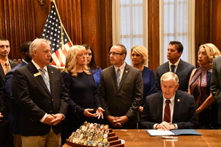 State Rep. Rocky Miller, Dennis & Tanya Newberry with Governor Mike Parson as he signs Child Sexual Assault Bill into law July of 2019.